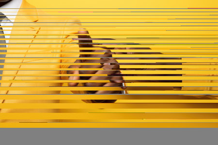 Person is pointing at something on vibrant yellow wall. Concepts such as communication, direction, guidance, or decision-making. Presentations, articles, blog posts, or advertisements.の素材