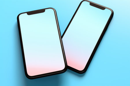 Pair of black and white smartphones on vibrant blue background. Perfect for technology-related projects and designs.の素材
