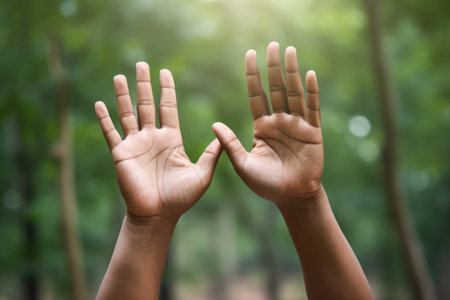 Person raising their hands in the air. Celebration, victory, surrender, or excitement.の素材