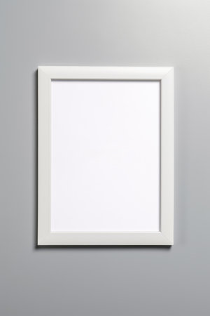 Simple white picture frame hanging on gray wall.の素材