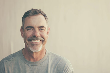 A man with a white beard and a gray shirt is smilingの素材