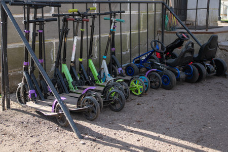 Scooters of various colors and models in a parking area, ready for use.