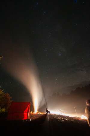A fire burning under the starry sky.の写真素材