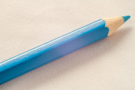 A simple pencil resting alone on a plain gray background.の写真素材