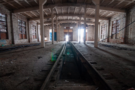 Bare and desolate interior of a dilapidated train station with exposed wooden beams and broken glass windows.の写真素材