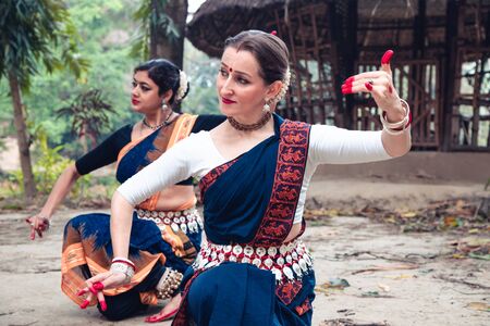 multinational group of beautiful young classical odissi dancers wears traditional costume and posing Odissi dance mudra in the rainforest.の写真素材