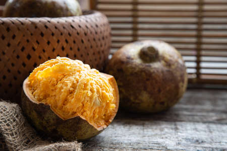 exotic Indian Bel fruit or wooden Apple. Bel fruit slices on wooden rustic background. natural...