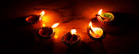 burning decorated ceramic oil lamp diya, on Happy Diwali, Shubh Diwali