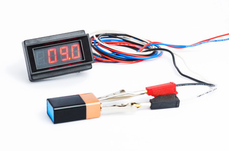 Testing battery with digital voltmeter illustration isolated on whiteの写真素材