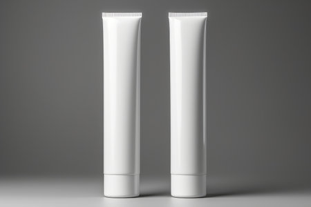 A high-resolution mockup of a blank white cosmetic tube on a subtle gradient background.の素材