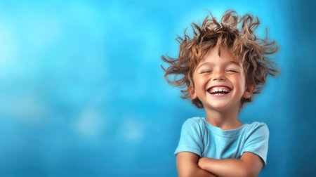 A happy young boy in a blue shirt smiles brightly against a colorful background.の素材