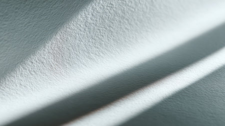 A high-key, abstract monochrome background showing smooth, flowing waves and folds of white paper or fabric, creating a sense of movement and texture with soft shadows, excellent for minimalist design, artistic presentations, and clean website backdrops.の素材