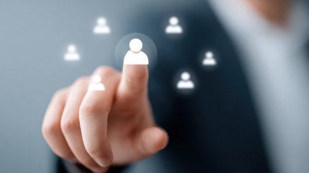 A hand reaches out to select a brightly glowing digital human icon from a group of blurred icons, symbolizing customer focus, selecting a target audience, or highlighting a key individual in a customer relationship management system. This image is perfect for marketing, HR, and business strategy content.の素材