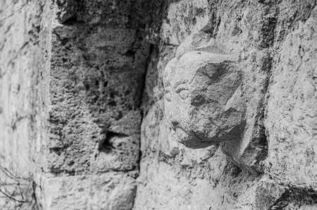 old head sculpted on a wall in the village of Saint-Cyr Lapopie.の写真素材