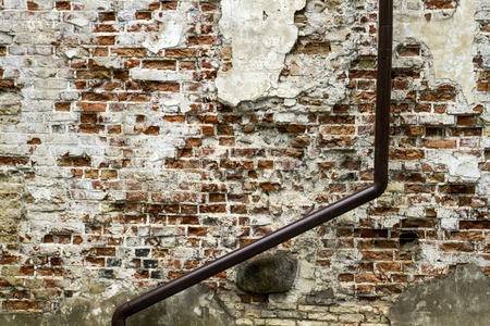 Grunge old bricklaying wall fragment from red bricks and damaged plaster background texture. Close upの写真素材