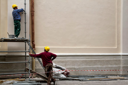 Construction workers in scaffolding restoration of the old building. Vilnius, Lithuania - June 20, 2016.のeditorial素材