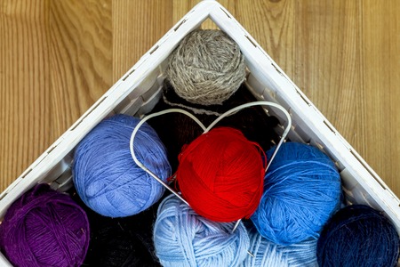 knitting wool color balls with needles in the basket