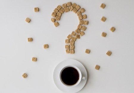 The question mark of sugar cubes and cup of coffee on a white background. Diet unhealty sweet addiction conceptの写真素材