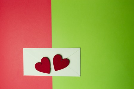 Envelop and two red hearts on colourful background. Top view. Copy space for text