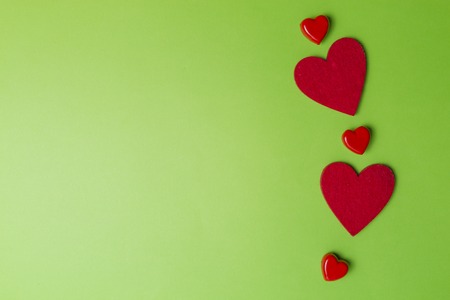 Red hearts greenery valentines day background. Minimal style. Flat lay. Top view. Copy spaceの写真素材