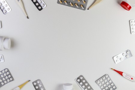 Pills border background. Vitamins, tablets, thermometers on white background. Top view. Copy space for textの写真素材