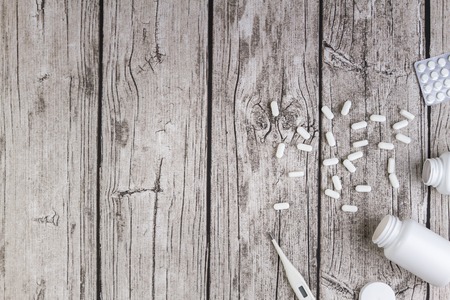 Medicine background. Vitamins, tablets, pills in blister pack, drugs bottles and capsules spilling out of a bottle. Top view. Copy space for textの写真素材