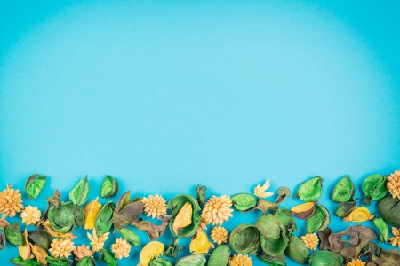 Dried flowers and leaves border frame on blue background. Top view, flat lay.の写真素材