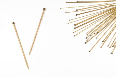 Variety of bamboo knitting needles in different sizes on white backgroundの写真素材