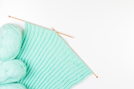 Balls of yarn and knitting and different size knitting needles on white backgroundの写真素材