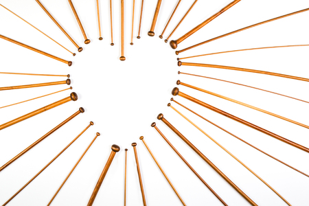 Heart symbol made of wooden knitting needles on white background.の写真素材