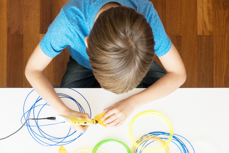 Child using 3D printing pen. Creative, technology, leisure, education concept