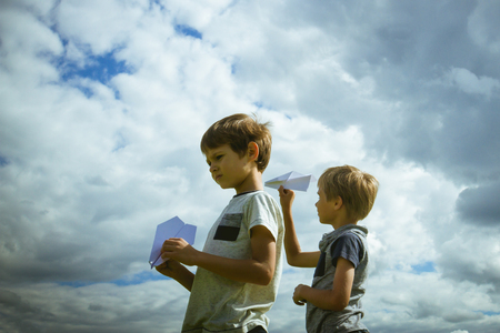 Little boys with paper planes against blue skyの写真素材