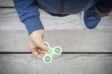 Kid spinning a fidget spinner device. Top viewの写真素材