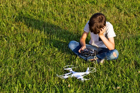 Little boy sitting on the grass with drone.の写真素材