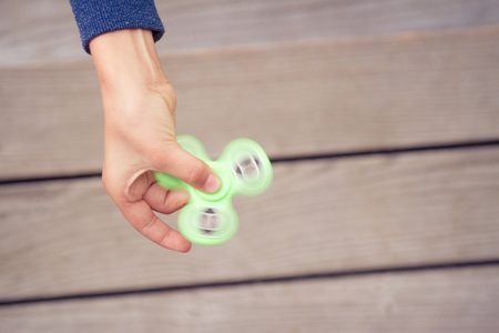 Kid holding popular fidget spinner toy. Top viewの写真素材
