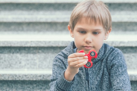 Boy with a fidget spinner outdoorsの写真素材