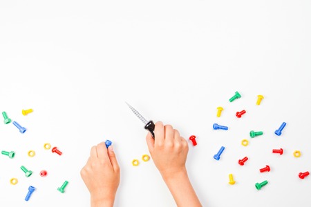 Top view on childs hands playing with colorful toys tools on the white background.の写真素材