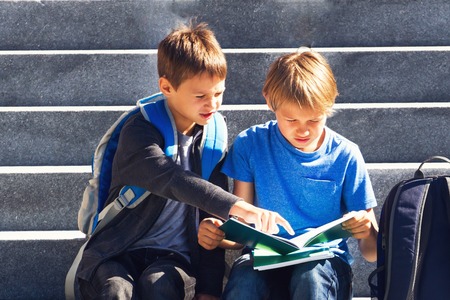 Two boys doing homework outdoors. Back to school concept.の写真素材