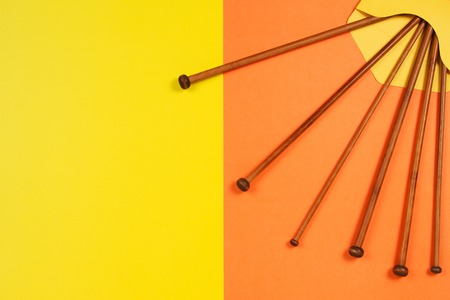 Variety of bamboo knitting needles in envelope on yellow and orange backgroundの写真素材