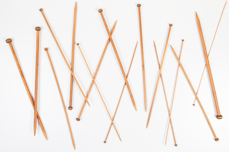 Wooden knitting needles in different sizes on white backgroundの写真素材