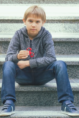 Boy with a fidget spinner outdoorsの写真素材