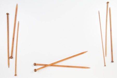 Wooden knitting needles frame with copy space for text on white backgroundの写真素材