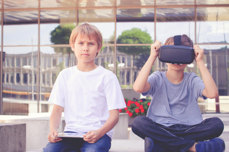 Two boys with virtual reality goggles and tablet computerの写真素材