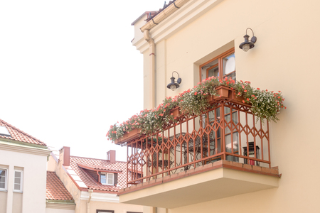 Small cozy classic style balcony with outdoor furniture, lighting and flowers.の写真素材