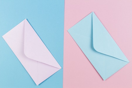 Pink and blue envelopes on colored pink and blue background. Top view.の写真素材