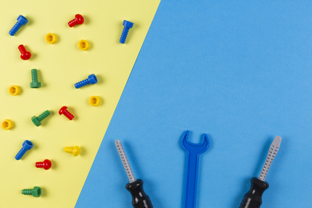 Toys background. Kids construction toys tools on blue and yellow background. Top viewの写真素材