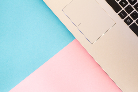 Top view of laptop notebook on blue and pink color backgroundの写真素材