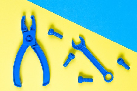 Toys background. Kids construction toys tools on blue and yellow background. Top viewの写真素材