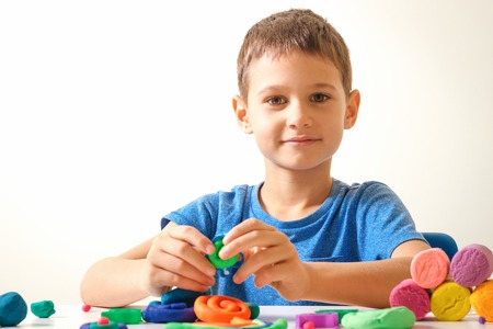 Boy playing and creating from modeling clay or plasticineの写真素材