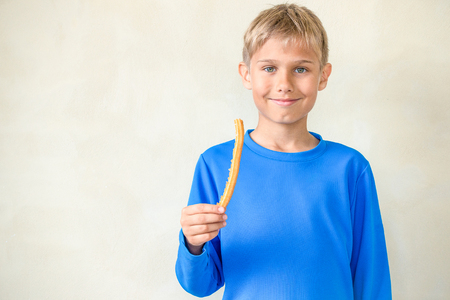 Smiling boy with famous Spanish dessert churrosの写真素材